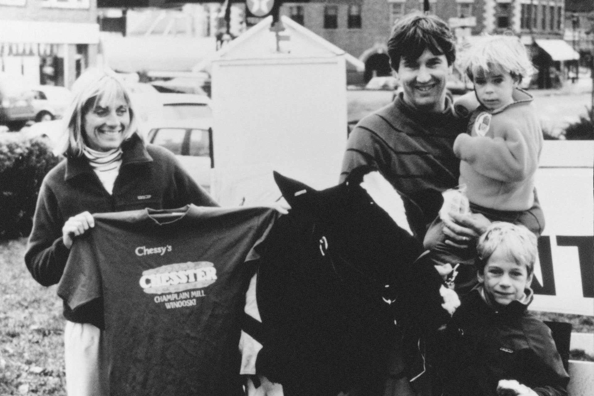 Ted and Anne Castle holding their young children in the 80s