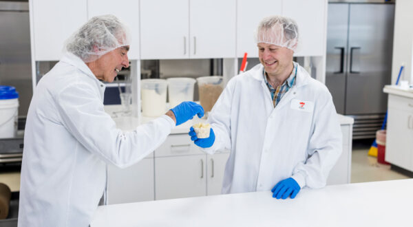 Two people sampling baked inclusions in a laboratory