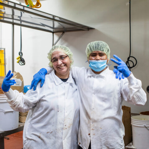 Two happy employees giving the peace sign